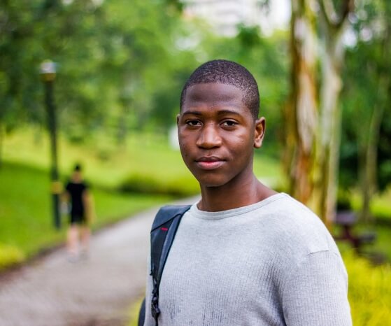An African American youth male standing in the park setting