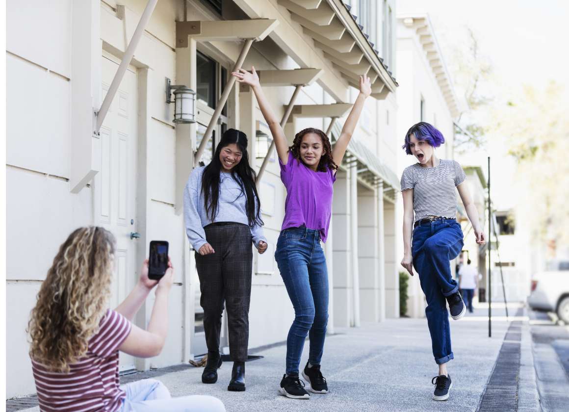 An image of a group of young people posing and filming on the sidewalk on a web page about Kids Help Phone’s mental health website