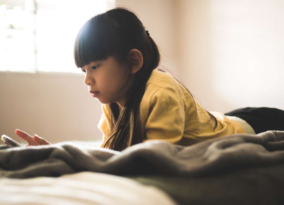 An image of a young person looking at a phone on a web page about Kids Help Phone’s mental health website