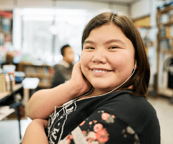 Am Indigenous female youth smilying, sitting in the classroom setting